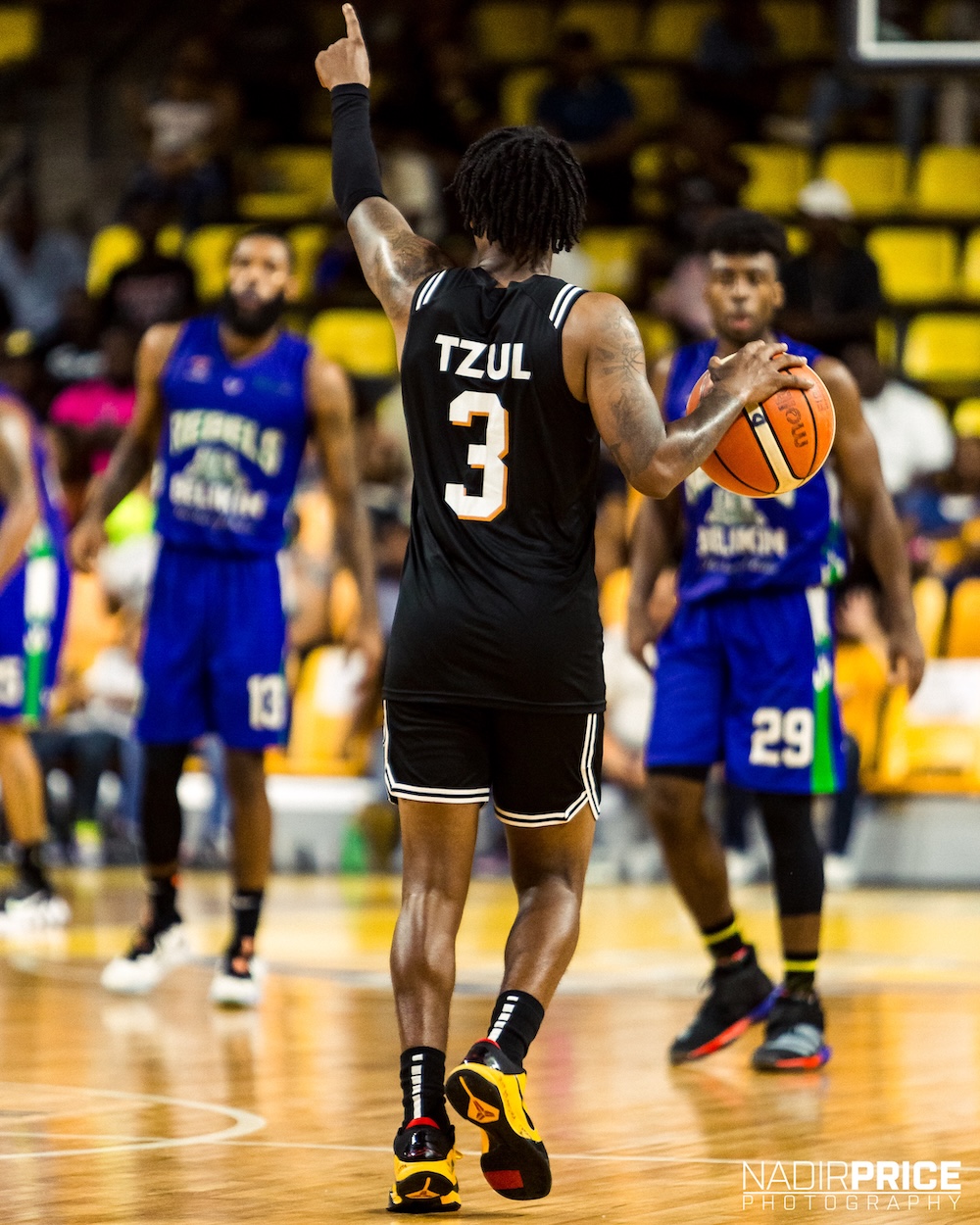 Myke signaling play in black jersey